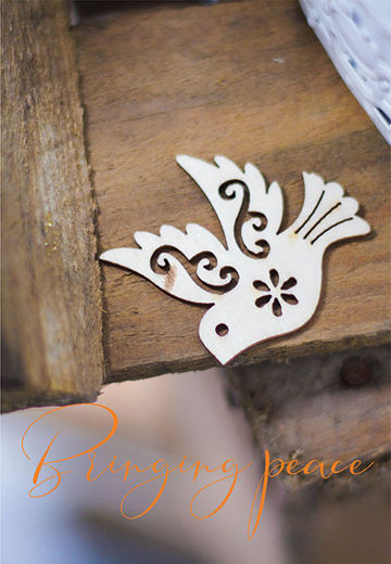Wood cutout of dove with caption 'Bringing peace'
